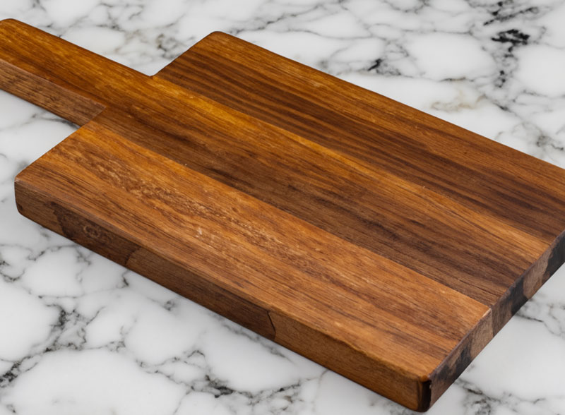 Walnut cutting board with handle on marble worktop